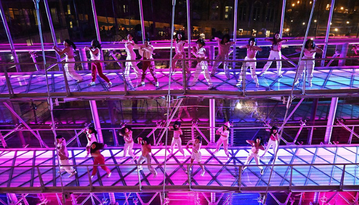 Lerner Hall floors and bridges with lights and  a dance team performing.