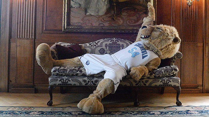 Roar-ee the mascot lounges on a couch.
