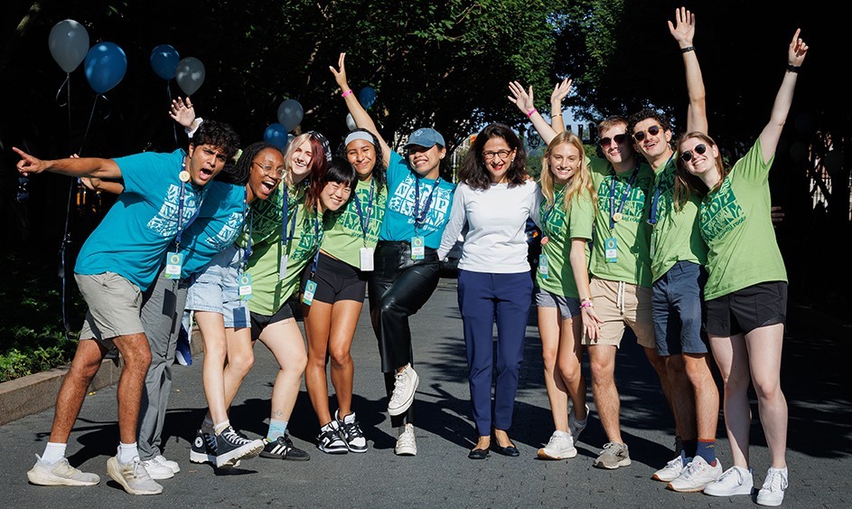Photo by Sirin Samman for Columbia Housing Ten students with Columbia President Minouche Shafik smile and cheer as they welcome new students to Columbia University.