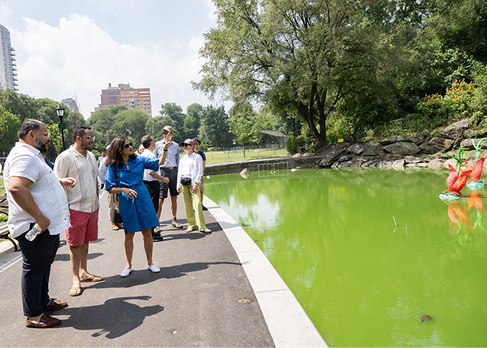 Manhattan Borough Commissioner of NYC Parks Anthony Perez, New York City Council Member Shaun Abreu, and Columbia University President Minouche Shafik observe the algae at the Morningside Park Pond. Photo by Diane Bondareff/Columbia University. President Minouche Shafik looks out of Morningside Pond filled with algae.