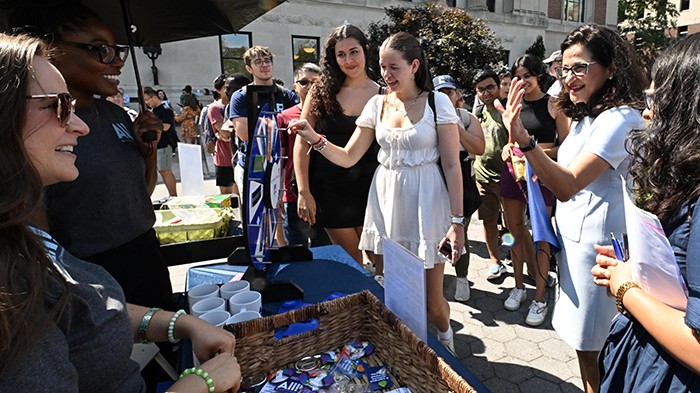 Students and President Minouche Shafik stop by a University Life table at the University Resource Fair