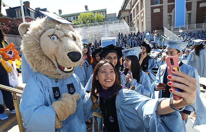A graduating student takes a selfie with Roar-EE.