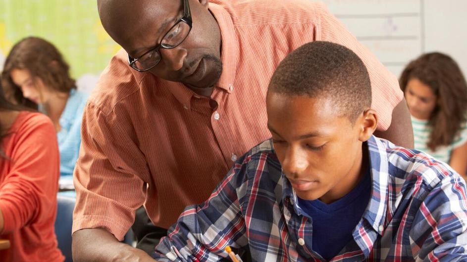 A stock photo of a teacher helping a student.