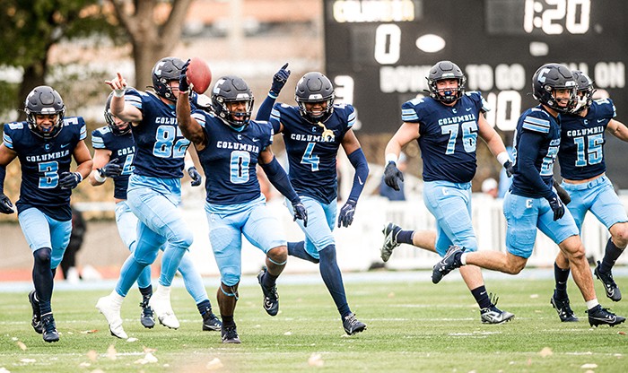 The Columbia defense celebrates a timely interception. Photo by Lem Marucot/Columbia Athletics. Columbia football team celebration.