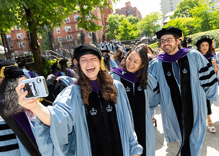 Columbia Law School grads pose for a celebratory selfie ahead of their Monday, May 13, graduation ceremony at Baker Athletics Complex. Photo by Sam Hollenshead. Columbia Law School Grads pose for a selfie.