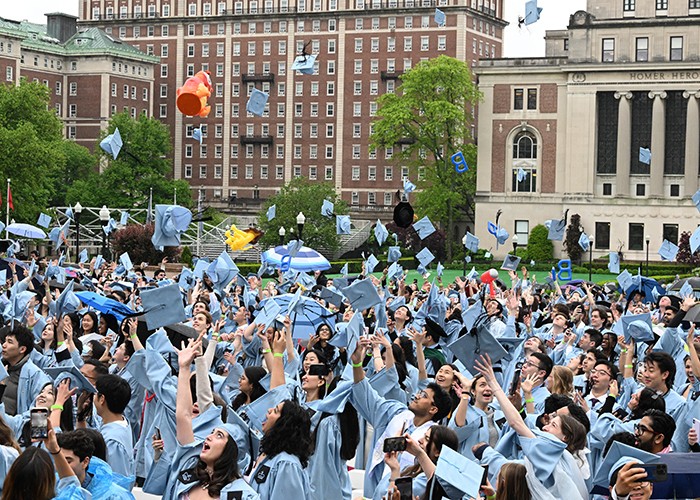 Graduates throw their mortar boards in the air on Morningside campus during University Convocation 2024: For Students, By Students festivities. Photo by Eileen Barroso. Graduates throw their mortar boards in the air on Morningside campus.