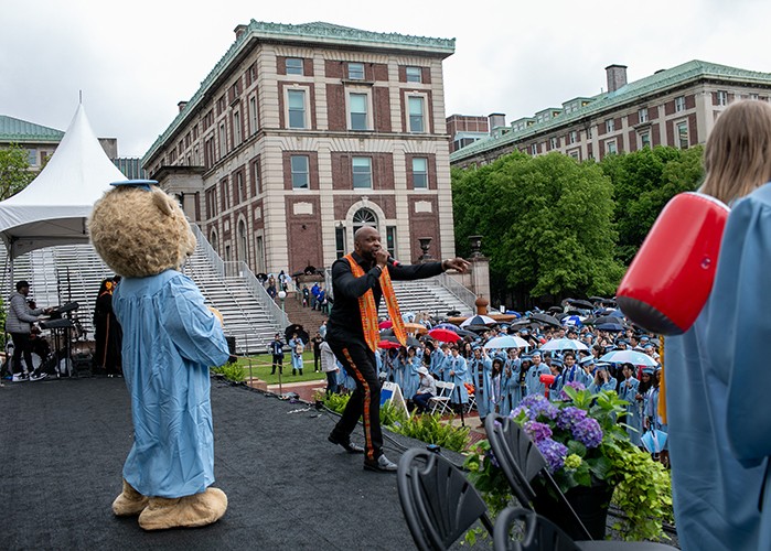 A snapshot from University Convocation 2024: For Students, By Students, which brought together graduates across all schools to celebrate their momentous accomplishment. Even Roar-EE came out for the fun! Photo by David Dini. Roar-EE and a member of Harlem Gospel Choir.