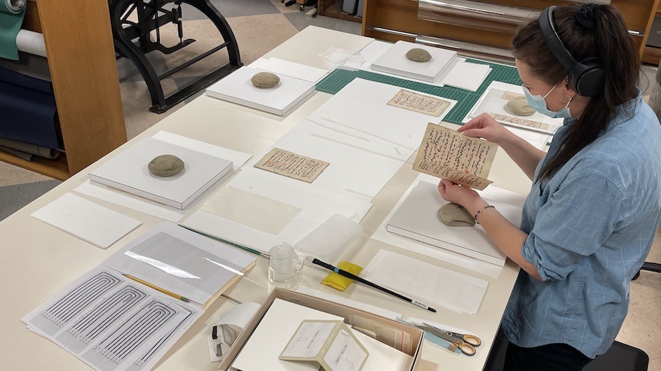 Abigail Slawik mends the leaves of the antiphonary to prepare it for re-sewing. (Credit: Morgan Adams/Columbia University Libraries) Abigail Slawik mends the leaves of the antiphonary to prepare it for re-sewing.