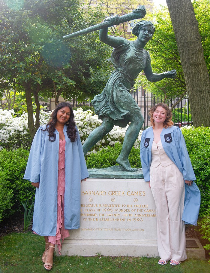 Barnard grads in front of an olympic games statue