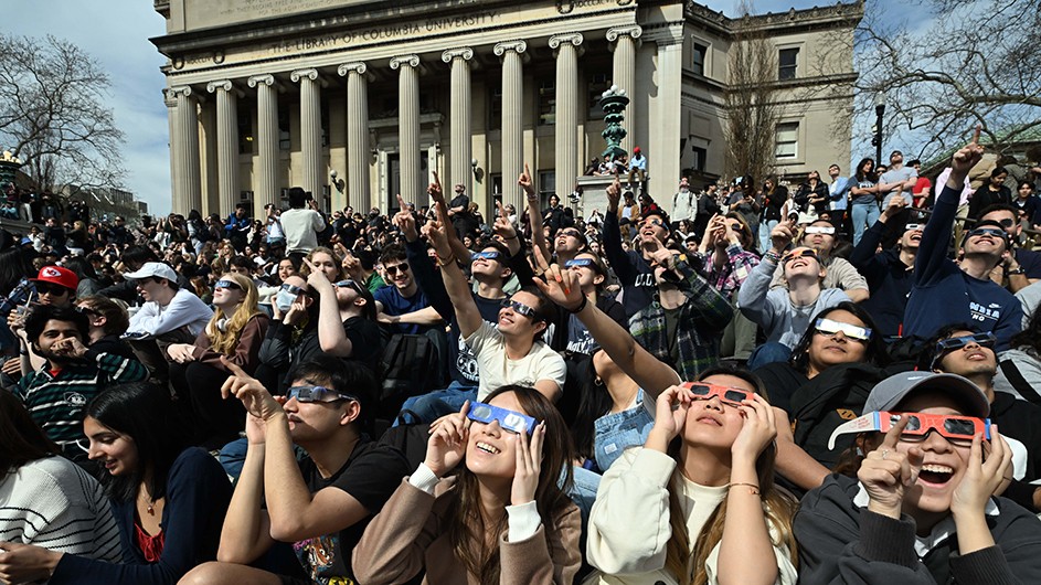 Columbia students point up at the solar eclipse.