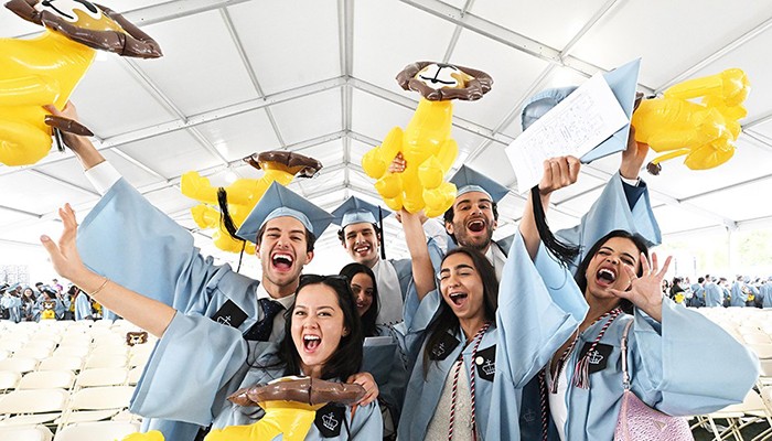 Photo by Eileen Barroso. Columbia College graduates wave lions at a graduation ceremony.