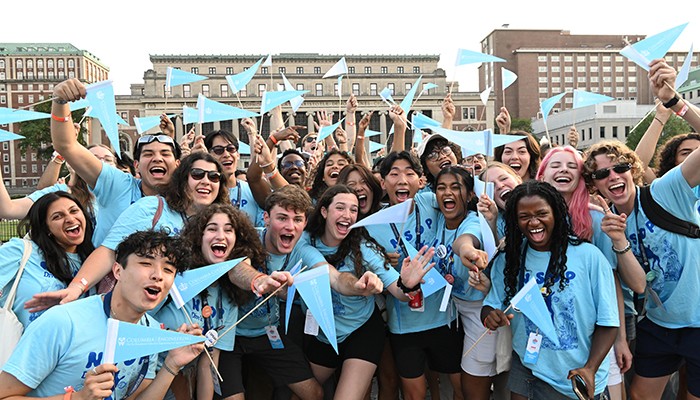Photo by Eileen Barroso/Columbia College. NSOP leaders wave flags to welcome Columbia's new students to campus.