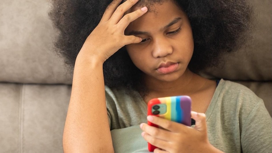 A young person looks at a smart phone.
