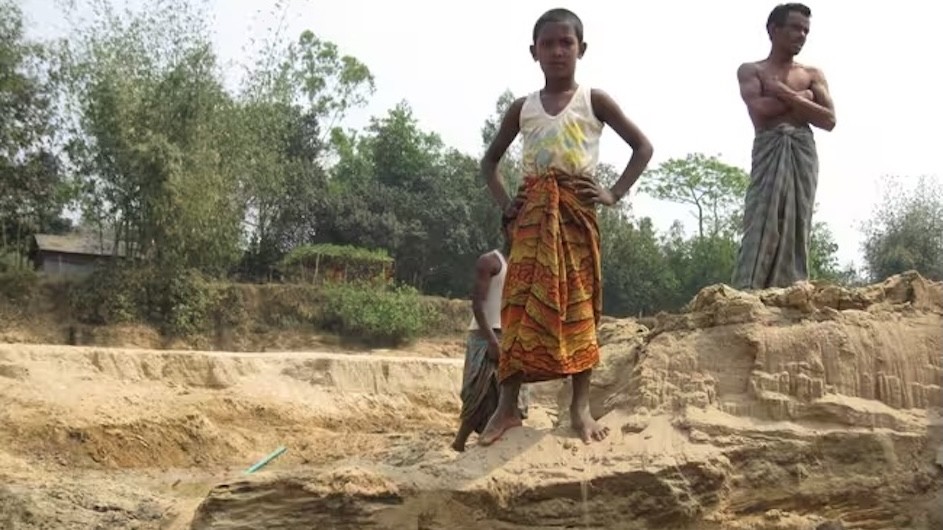 People who are unable to flee natural disasters and areas of high climate risk are vulnerable, and understudied. Here, surveying a dried-up riverbed in northern Bangladesh. 