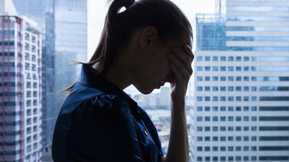 economic struggles, woman with head in hand/shutterstock