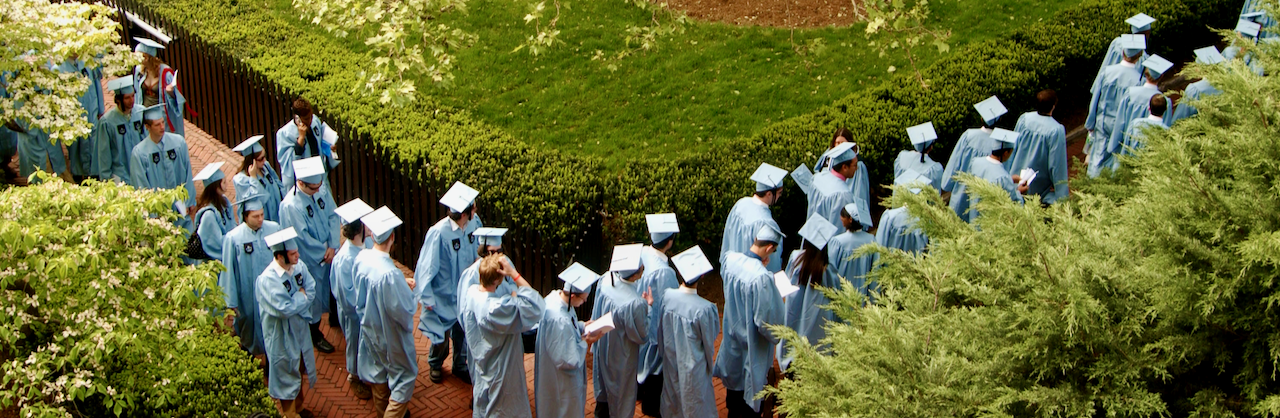 Graduates lineup among the greenery on Columbia's Morningside campus