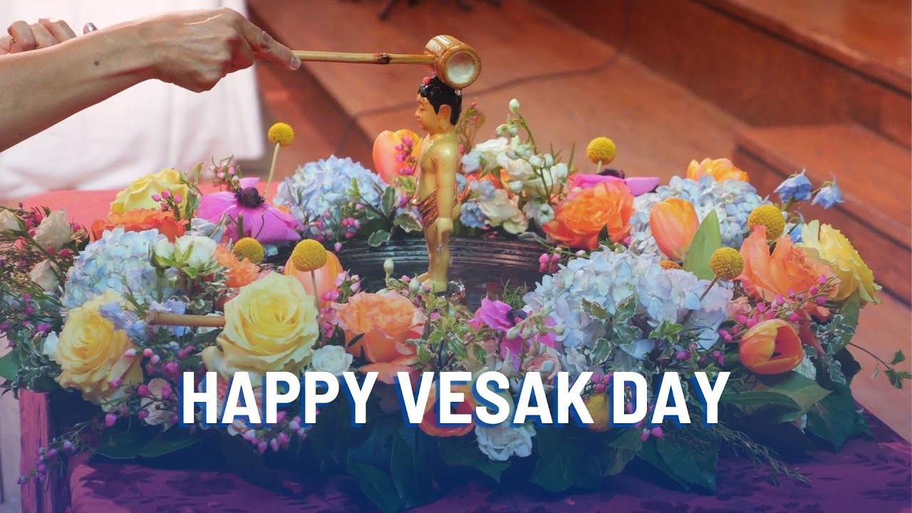 A Buddha icon on a wreath of flowers with the words "Happy Vesak Day"