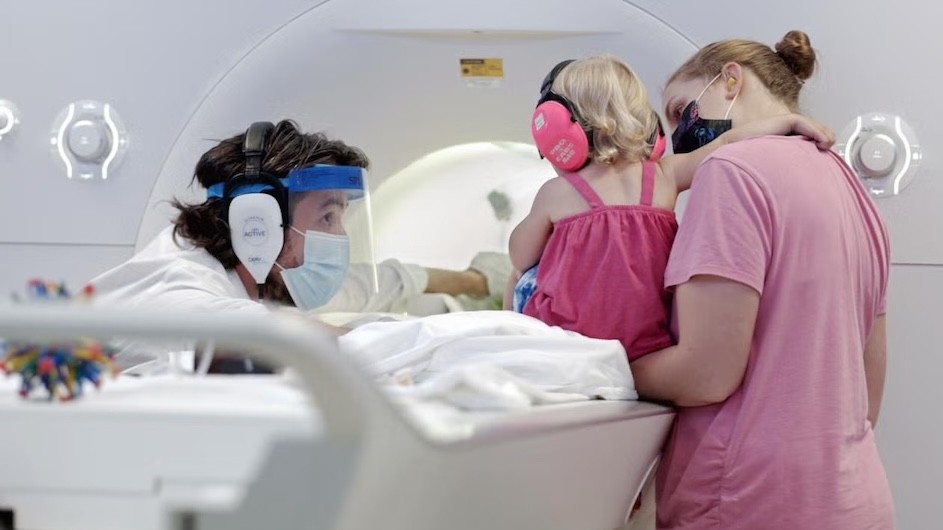 Yale's Professor Nick Turk-Browne (left) preparing a child participant and parent for an infant MRI study in the Brain Imaging Center (now BrainWorks) at Yale University circa 2021.
