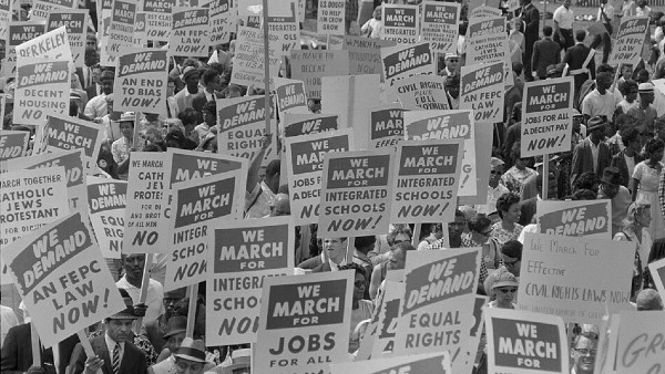 1963 March on Washington with people holding signs reading "We March for Integrated Schools Now!"