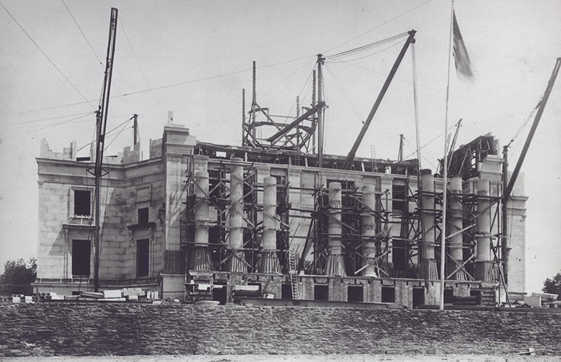 a vintage image in black and white of the construction of low memorial with the building support beams located on the exterior during construction