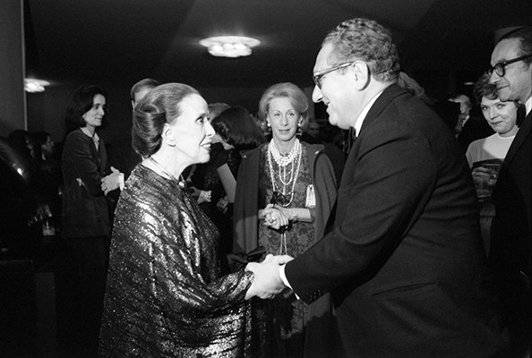 Martha Graham and Henry Kissinger, with Nancy Kissinger and Alan Greenspan observing, Nov. 16, 1976. (c)Karl Schumacher | Gerald R. Ford Presidential Library and Museum. A man and a woman greeting each other holding hands as others look on