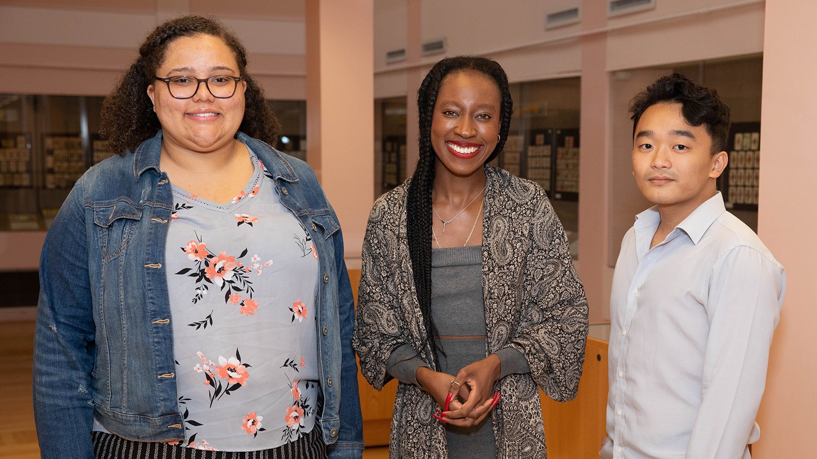 Three Columbia students (from left: Keziah Anderson, Bérénice Sylverain, Tommy Song) who use the Rare Book & Manuscript Library to research African American and African Diaspora Studies topics. Photo: Christian Balmer Two young women with long hair and a young man standing and smiling at the camera