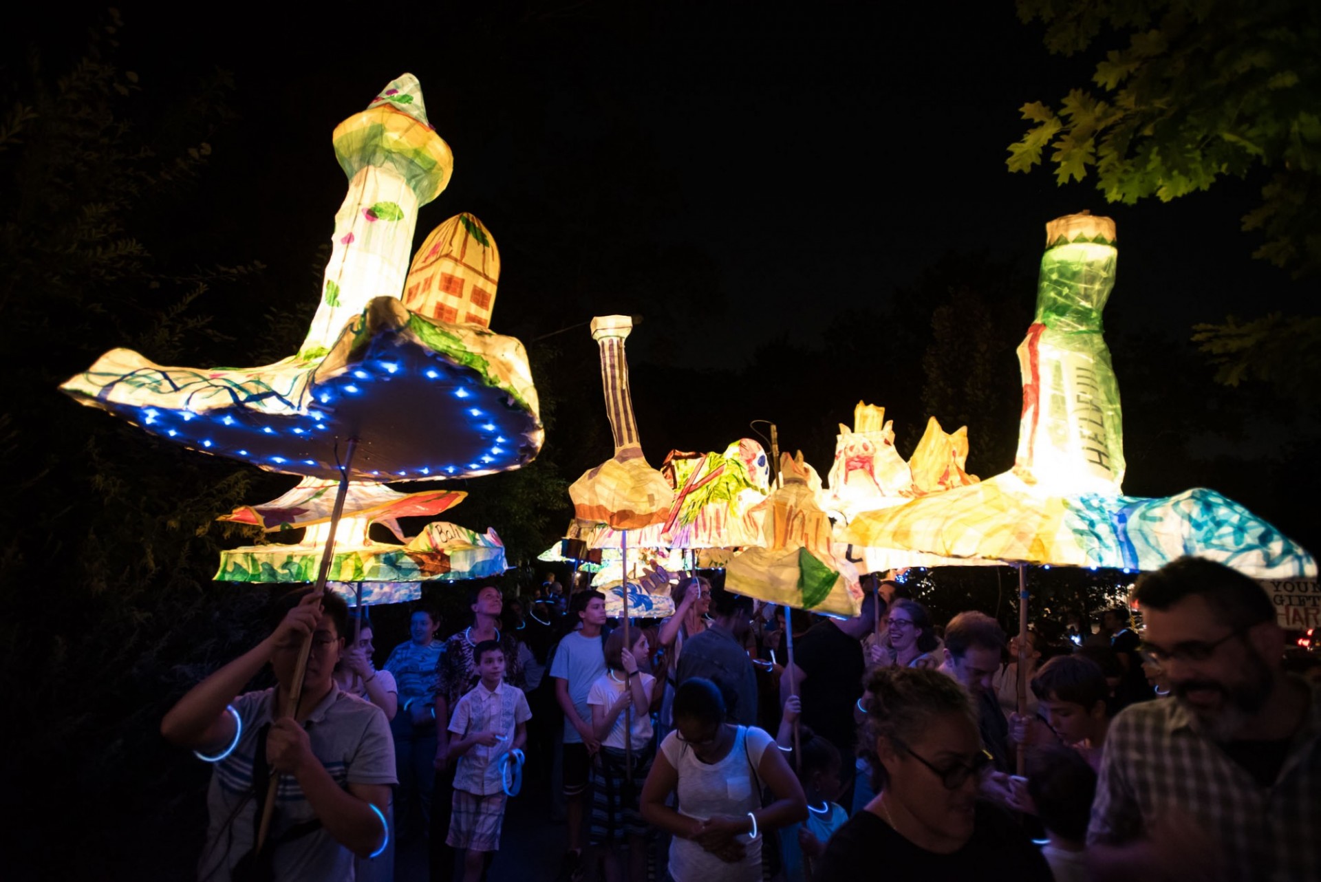 The annual Morningside Lights procession featured an island theme. A crowd of people at night holding lit lanterns.