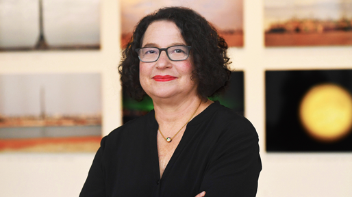 Betti-Sue Hertz Betti-Sue Hertz posing in front of paintings in Wallack gallery