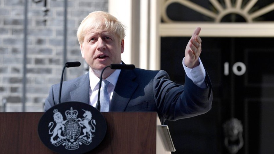 New British Prime Minister Boris Johnson outside 10 Downing Street. (Jeff J Mitchell/Getty Images) A man wearing a suit with a hand raised speaking into a microphone