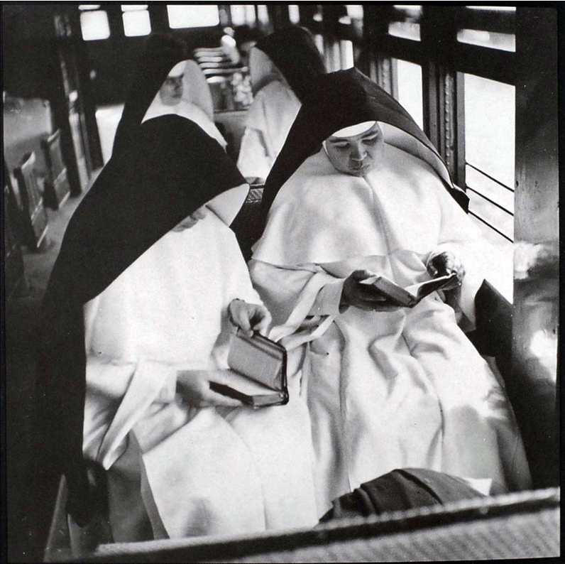 Four nuns sitting on wooden pews in a train. Photo Courtesy of the Delano Collection at Rare Book and Manuscript Library