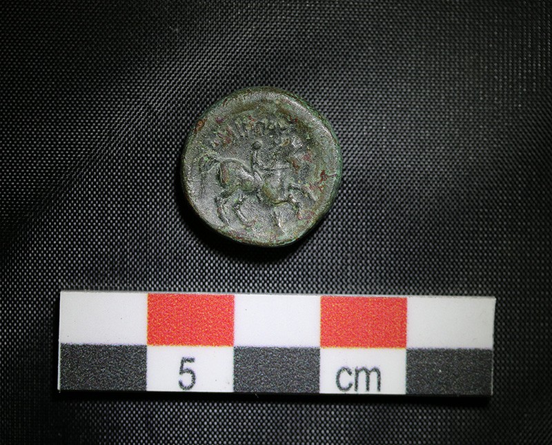 Bronze coin from Macedonia (horse rider), Philip II, inscribed with the name of the king. Image Courtesy of © Onchestos Excavation Project Coin