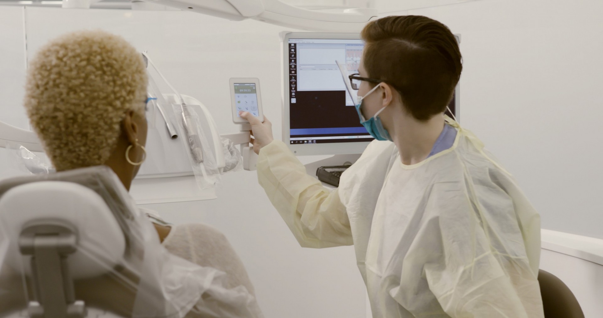 A dentist shows a screen to a patient
