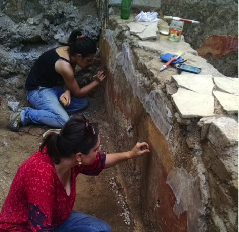 Advanced Program of Ancient and Art History team members at work preserving and restoring wall paintings and marble decoration. Photo by A. Tartaro Two people work on an exposed brick wall