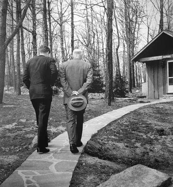 John F Kennedy and Dwight Eisenhower walk on a path