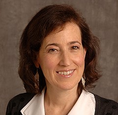 Photo of Claude Mellins, a woman with brown hair in a suit