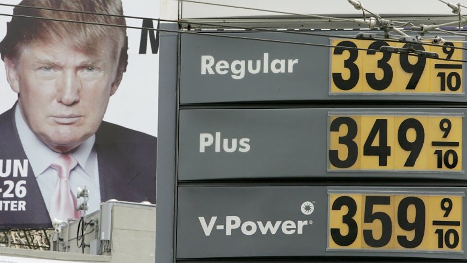 A man on a billboard next to a sign showing gas prices