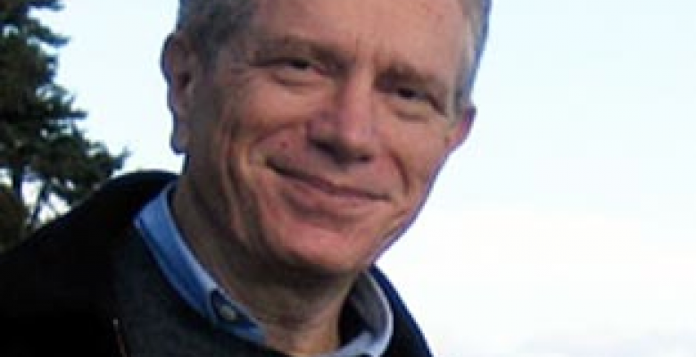 David Freedberg looks into camera wearing a dark colored jacket with a light blue button down shirt underneath