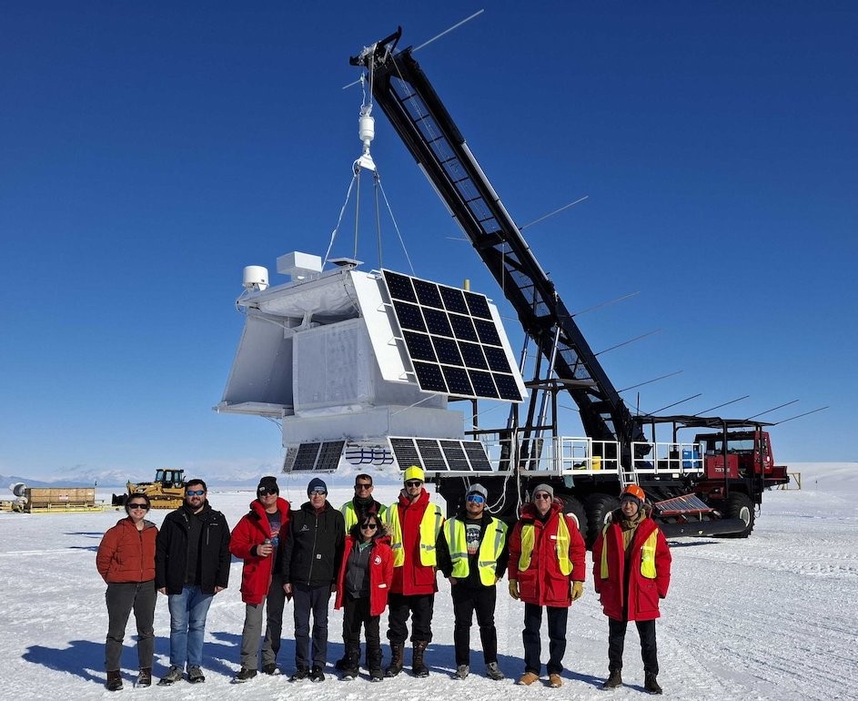 The GAPS team poses for a photo in Antarctica in front of the experiment equipment. The GAPS team poses for a photo in Antarctica in front of the experiment equipment.