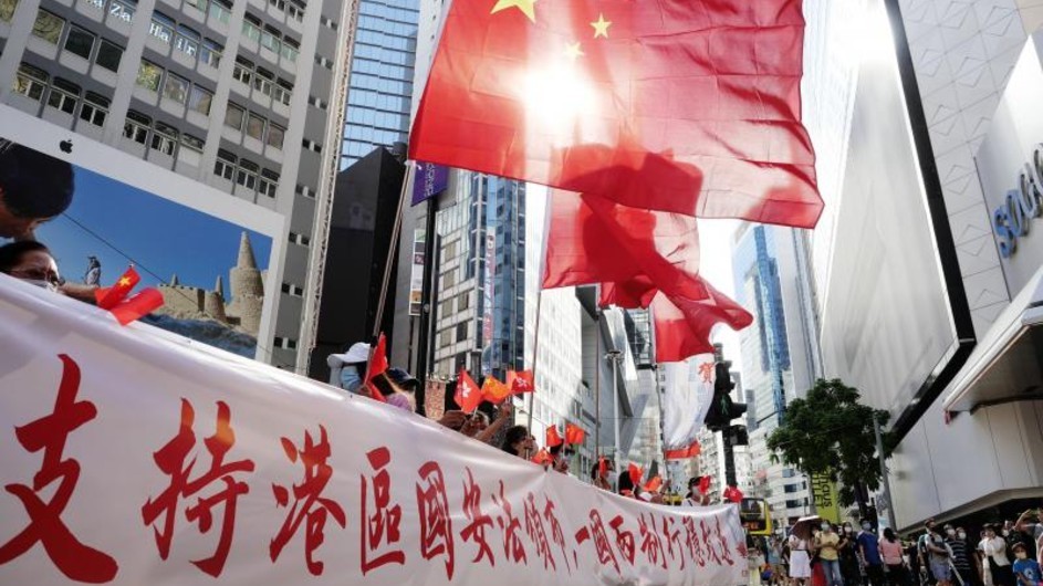Supporters of China’s new security law celebrate in Hong Kong, June 2020. Wang Shen | Xinhua PRC flags are flown above a banner with Chinese characters.