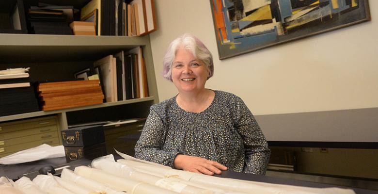 janet parks standing in an office surrounded by books and shelves 