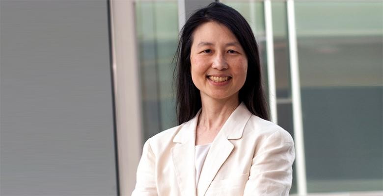 Jeannette Wing dressed in an off white blazer with a white blouse underneath. Long dark hair placed behind shoulders