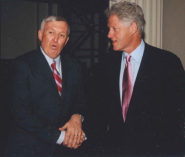 Jackson with President Bill Clinton. Two men in suit conversing standing up