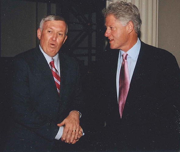 Two men in suit conversing standing up