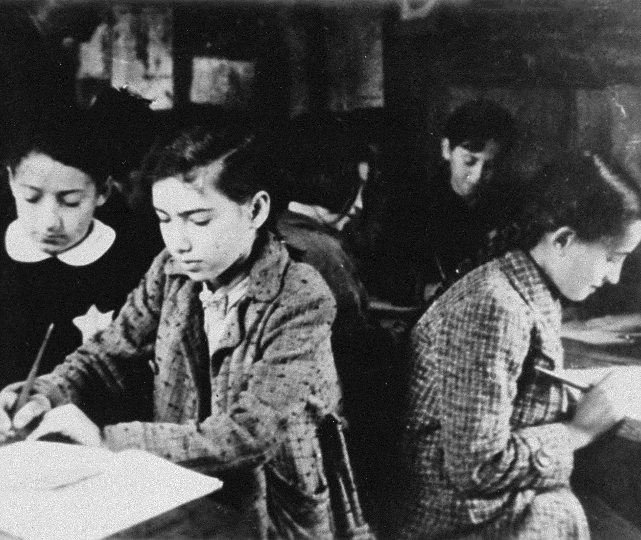 Clandestine school, Kovno ghetto, Lithuania, 1941-42. Students work at desks.