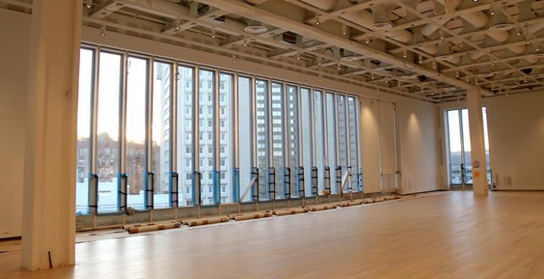 Open space of wooden floors, tan columns and full view glass windows of the Lenfest Center for the Arts