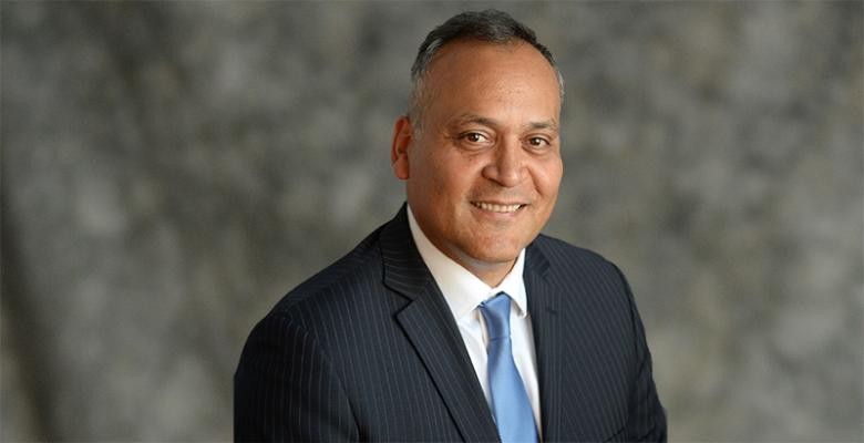Marco Velez in dark suit white shirt and blue tie