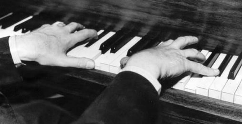 Man's fingers playing keys on a piano