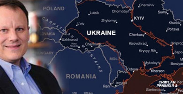 The head and shoulders of a man are superimposed on the left edge of an image that is a map of Ukraine.
