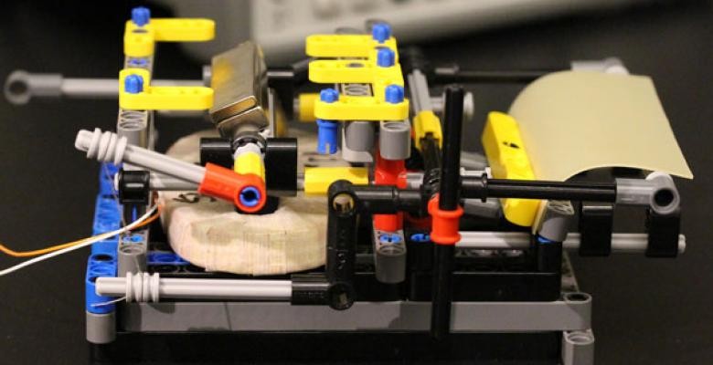 An evaporation harvesting device made of Legos, a spore-coated rubber sheet, a coil and a magnet. The device produces electricity when sheet bends and straightens in response to moisture. Image Credit: Xi Chen/Columbia University Machine made with yellow and blue bolts