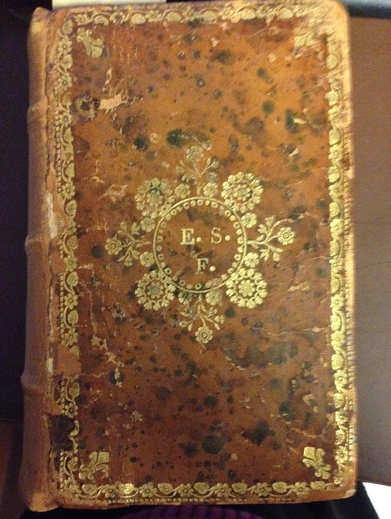 This is a Columbia book whose binding tells us the initials of one (or two) owners in 18th century Italy. A leather-bound book with elaborate gold lettering and floral motif